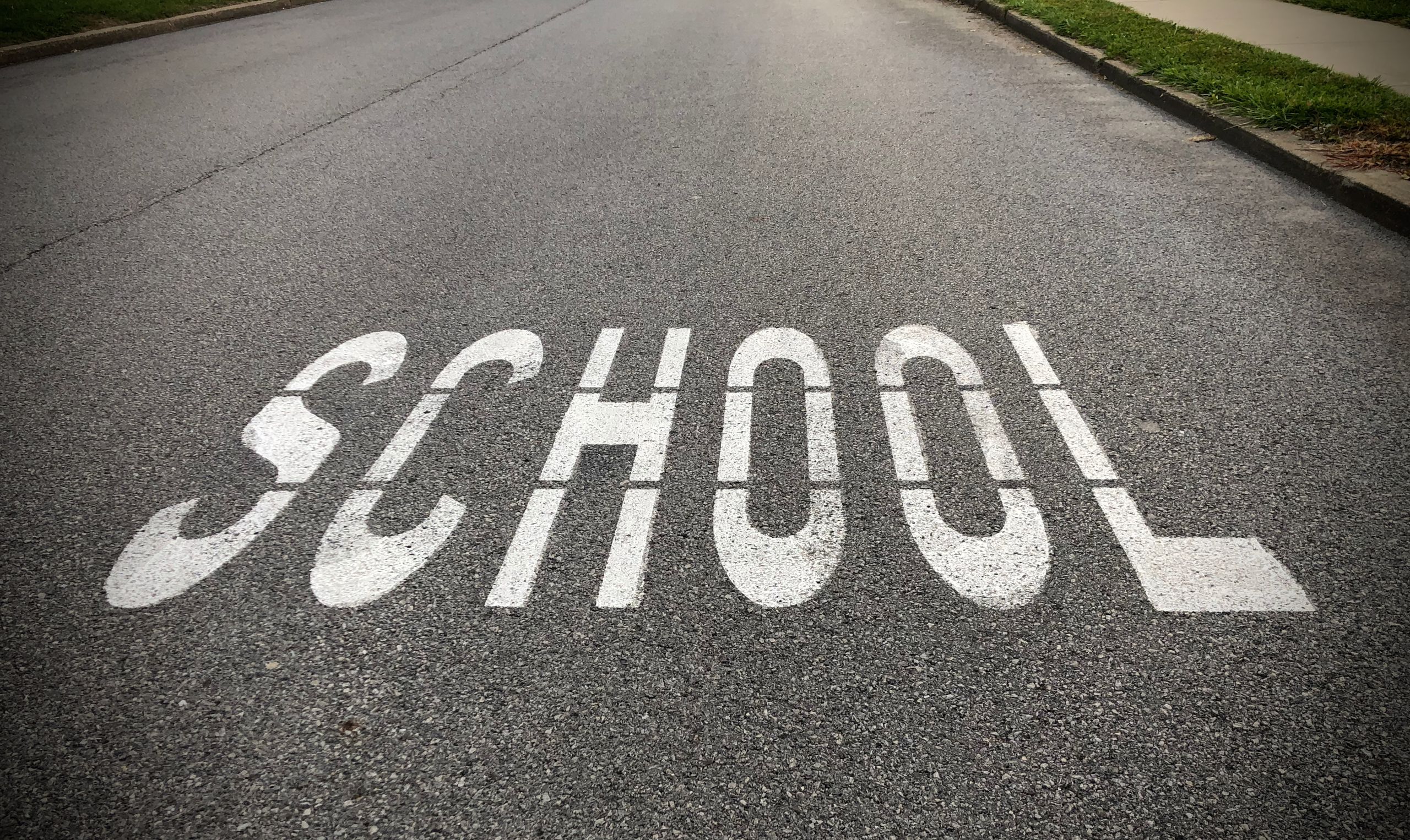 Close-up of 'School' road marking in a school zone, Zelienople, PA.